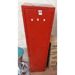 A red painted metal gun cabinet - with keys - paint peeling and corrosion