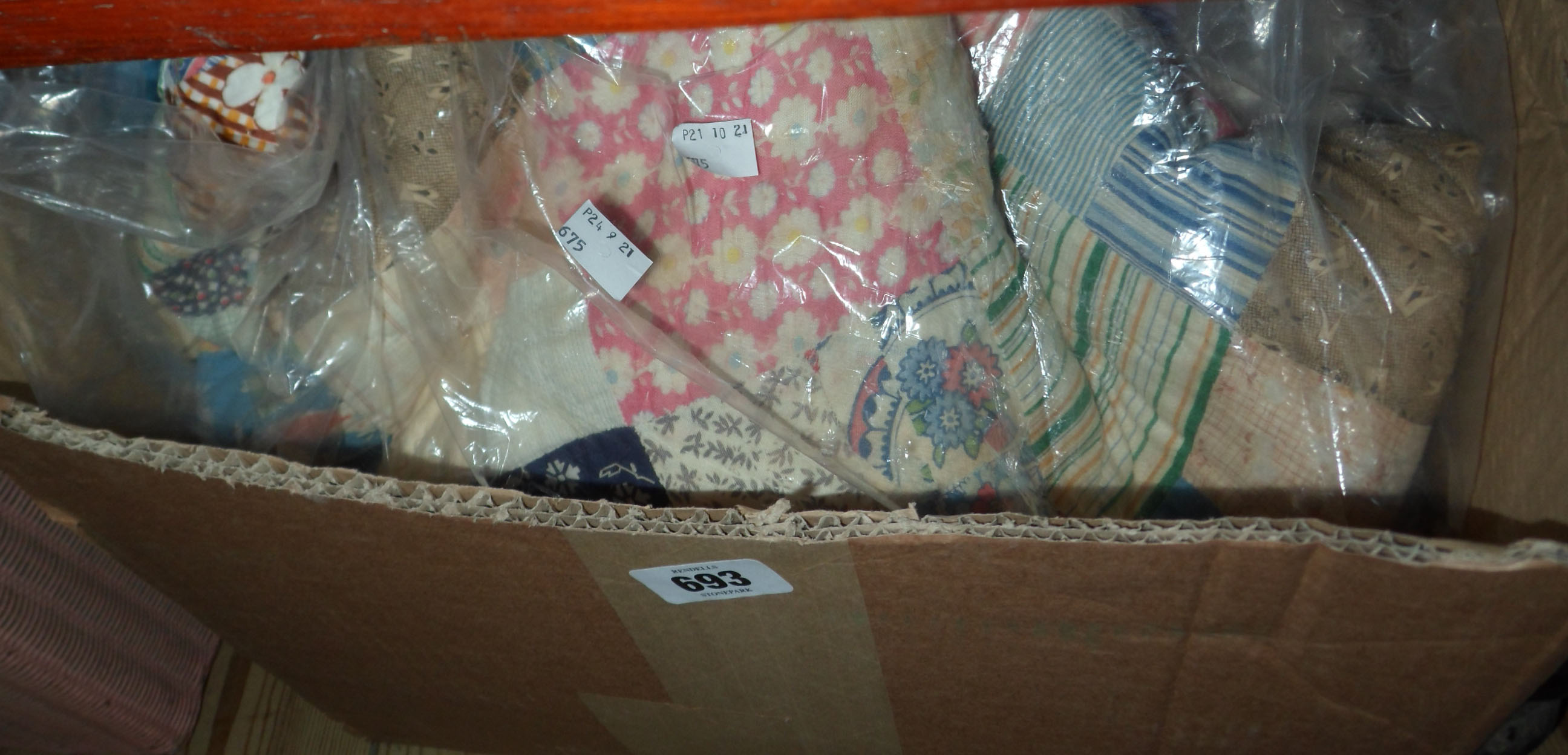 A box containing a vintage patchwork quilt and a similar bedspread
