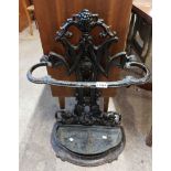 An old Victorian cast iron stick stand of bow top form with original drip tray