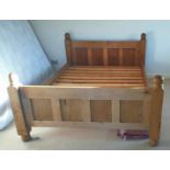 A 1.52m stained pine double bedstead with panelled head and footboards, slatted base and side rails