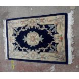 A modern Chinese washed wool mat with central motif and floral border - 100cm X 62cm