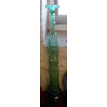 A large vintage green glass bottle and stopper in the form of a classical maiden holding an urn