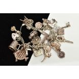 A WHITE METAL CHARM BRACELET, suspending twenty-seven charms in forms such as a house, web,boots,