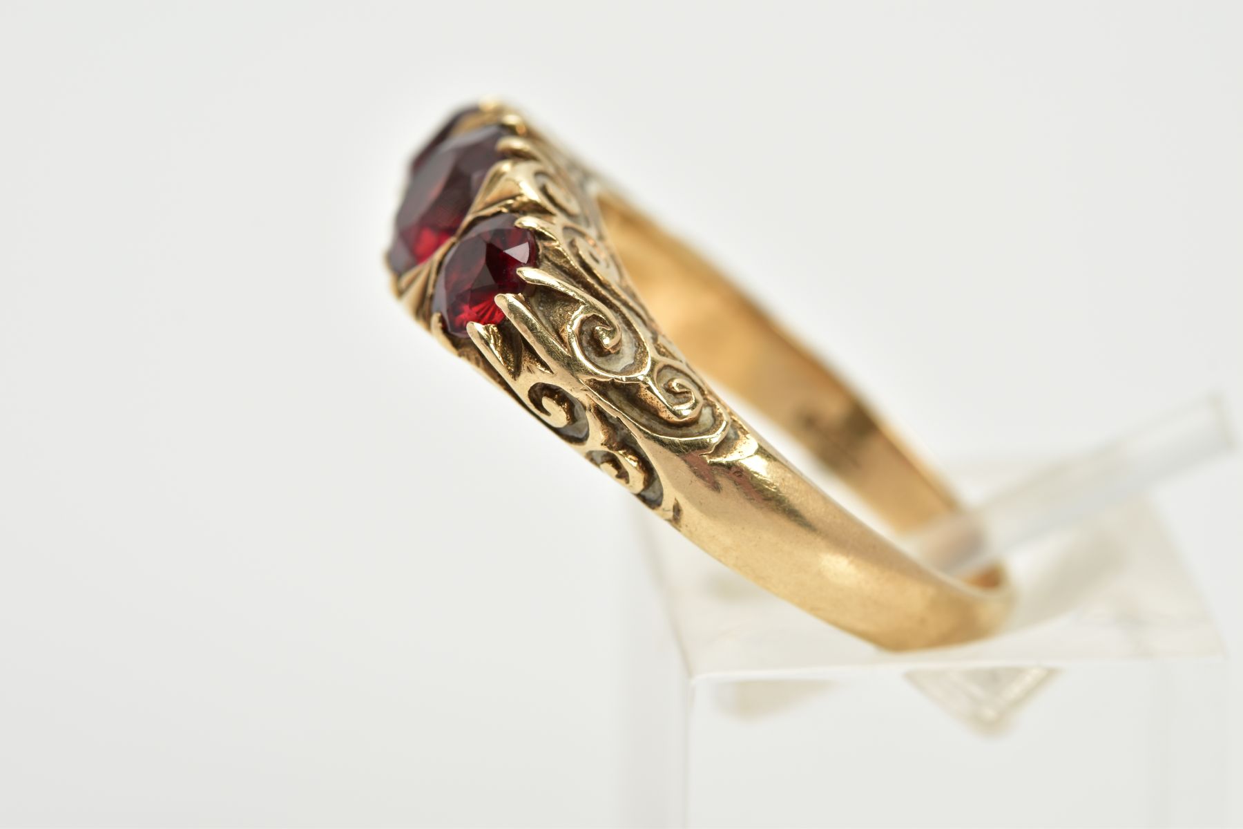 A 9CT GOLD THREE STONE GARNET RING, set with three graduated circular cut garnets, within a scroll - Image 2 of 3