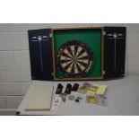 A CASED TWO DOOR DART BOARD, with a collection of accessories to include six sets of three darts,