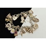 A WHITE METAL CHARM BRACELET, suspending nineteen charms in forms such as a heart shaped jewellery