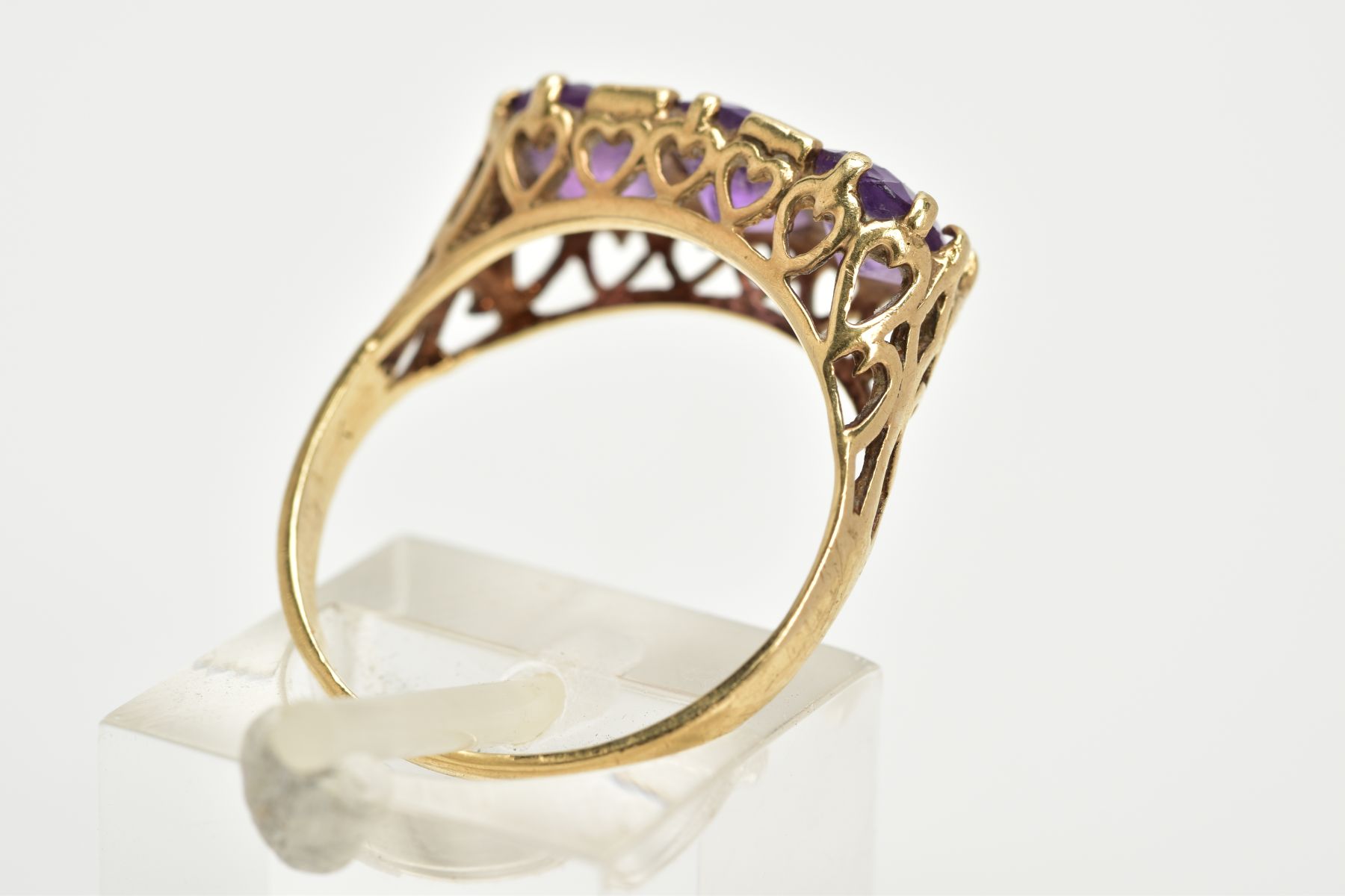 A 9CT GOLD THREE STONE AMETHYST RING, three claw set oval cut amethysts, within a raised openwork - Image 3 of 3