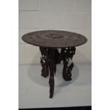 AN ANGLO INDIAN OAK CIRCULAR OCCASIONAL TABLE, the carved top with mythical bird, on triple legs,