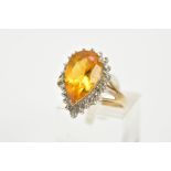 A 9CT GOLD CITRINE CLUSTER RING, designed with a central claw set, pear cut citrine, within a single