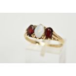 A 9CT GOLD THREE STONE RING, designed with a central oval cabochon opal, flanked with oval cut