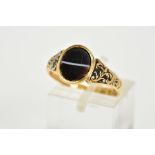 AN EARLY VICTORIAN 18CT GOLD AGATE RING, designed with an oval agate panel, foliate black enamel