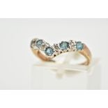 A 9CT GOLD TOPAZ AND DIAMOND WISHBONE RING, set with five circular cut blue topaz, interspaced