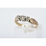 A YELLOW METAL THREE STONE DIAMOND RING, designed with three graduated illusion set single cut