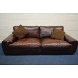 A BROWN LEATHER TWO SEATER SETTEE with two cushions width 240cm x depth 100cm