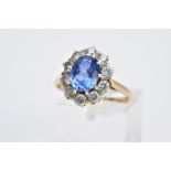 A 9CT GOLD CLUSTER RING, designed with a central oval cut blue sapphire, within a circular cut cubic