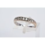 AN 18CT WHITE GOLD DIAMOND HALF ETERNITY RING, designed with a row of seven channel set round