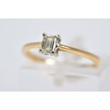 AN 18CT GOLD SINGLE STONE DIAMOND RING, designed with a claw set rectangular cut diamond, tapered