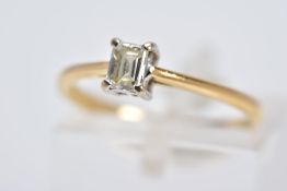 AN 18CT GOLD SINGLE STONE DIAMOND RING, designed with a claw set rectangular cut diamond, tapered