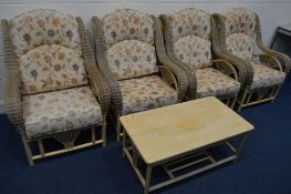 A FIVE PIECE CONSERVATORY SUITE with floral cushions comprising four armchairs and a coffee table (