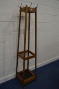 A MID TO LATE 20TH CENTURY GOLDEN OAK HAT/COAT STAND with eight hooks and tin tray 41cm squared x