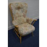 AN ERCOL BEECH MODEL 364 EASY ARMCHAIR with floral cushions