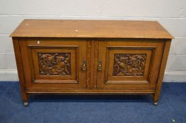 AN EARLY 20TH CENTURY GOLDEN OAK TWO DOOR SIDEBOARD with foliate carved panels fitted interior on