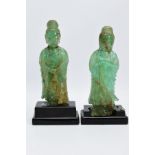TWO ORIENTAL CARVED FIGURES, believed to be green fluorite, each with a wooden base (one base