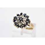 A 9CT GOLD SAPPHIRE AND DIAMOND CLUSTER RING, the large slightly raised cluster set with a central