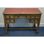 AN OLD CHARM OAK DESK with a bright red and gilt tooled leather inlay top five drawers on turned