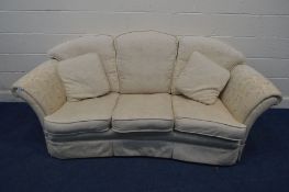 A CREAM UPHOLSTERED CONCAVE THREE SEATER SETTEE 205cm