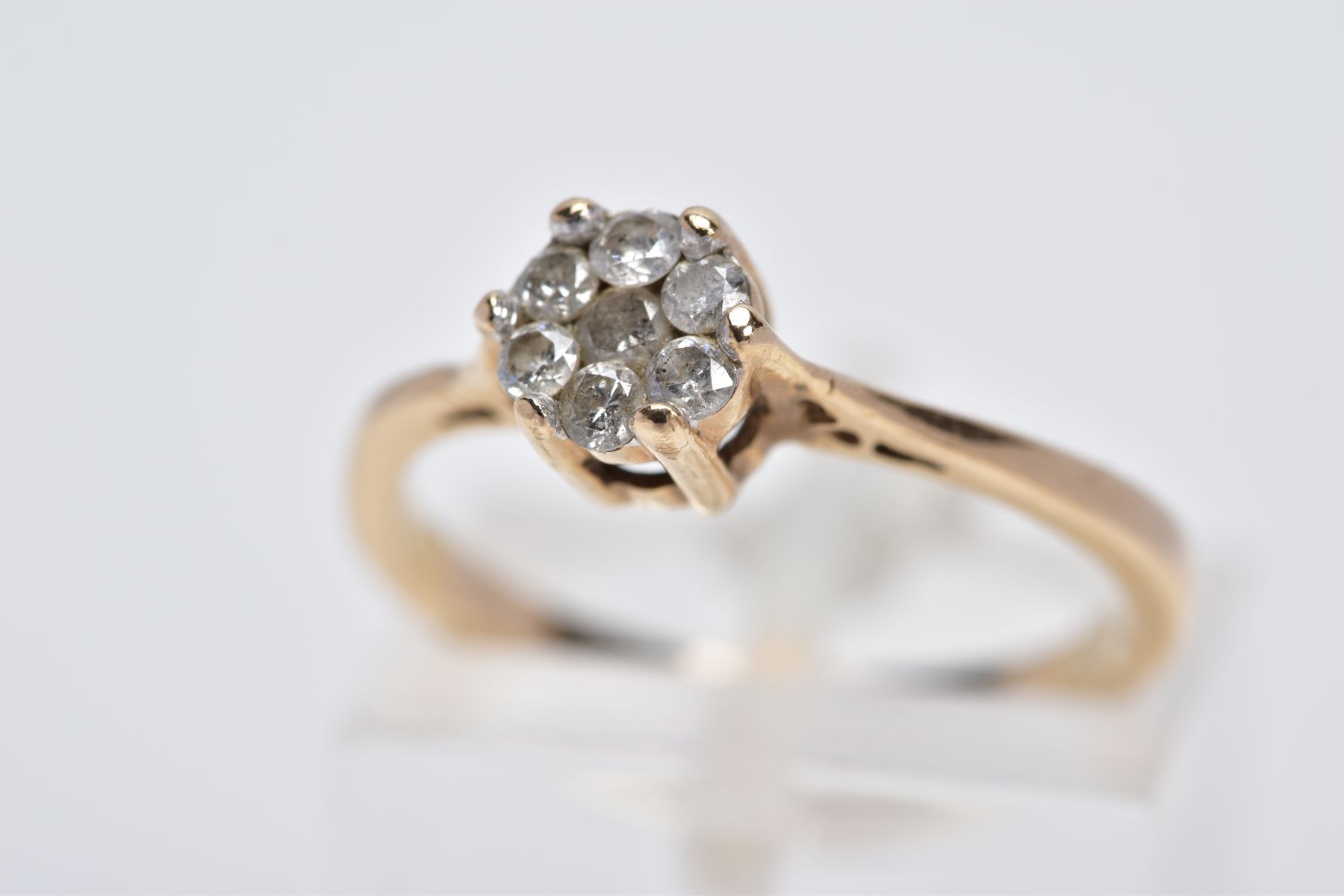 A 9CT GOLD DIAMOND CLUSTER RING, designed with a smaller cluster of seven brilliant cut diamonds,