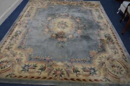 A CHINESE WOOLLEN BLUE AND CREAM GROUND CARPET SQUARE 306cm x 206cm (sd and in need of cleaning)