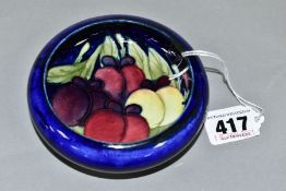 A MOORCROFT POTTERY LIPPED BOWL, the interior decorated with Wisteria (plums) on a blue ground,