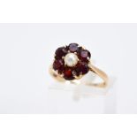 A 9CT GOLD GARNET AND PEARL CLUSTER RING, designed with a central single cultured pearl, within a