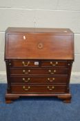 A REPRODUCTION GEORGE III MAHOGANY AND CROSSBANDED MINIATURE BUREAU fitted interior above five