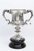 A SILVER TROPHY CUP WITH STAND, the double handled trophy cup of a foliate and scroll detailed