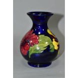 A MOORCROFT POTTERY SQUAT BALUSTER VASE, yellow and red hibiscus on a blue ground, impressed
