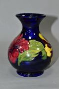 A MOORCROFT POTTERY SQUAT BALUSTER VASE, yellow and red hibiscus on a blue ground, impressed