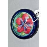 A SMALL MOORCROFT POTTERY LIPPED DISH, 'Hibiscus' pattern on blue ground, impressed backstamp,