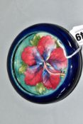A SMALL MOORCROFT POTTERY LIPPED DISH, 'Hibiscus' pattern on blue ground, impressed backstamp,