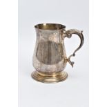 A SILVER TANKARD, of a plain polished design, bell shaped body on a circular base with a foliate