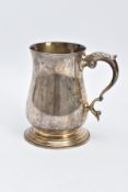 A SILVER TANKARD, of a plain polished design, bell shaped body on a circular base with a foliate