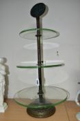 AN EARLY 20TH CENTURY THREE TIER GLASS ADVERTISING DISPLAY STAND, the iron and worn brassed stand