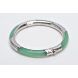 A WHITE METAL AND JADE HINGED BANGLE, jade bangle lined with a decorative white metal lining, fitted