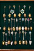 A CASED COLLECTION OF SILVER AND SILVER PLATED GOLFING TEA SPOONS, housed in a wooden glass