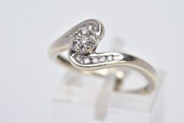 A 9CT WHITE GOLD CROSS OVER DIAMOND RING, designed with a central circular section set with seven