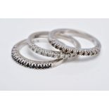 THREE WHITE METAL DIAMOND STACKING RINGS, each designed as a half hoop ring, the first set with a
