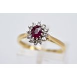 AN 18CT GOLD RUBY AND DIAMOND CLUSTER RING, designed with a central claw set, oval cut ruby within a