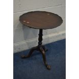 AN EARLY 20TH CENTURY MAHOGANY DISH TOP TRIPOD TABLE, with a wavy edge, diameter 52cm x height