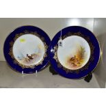A PAIR OF ROYAL WORCESTER CABINET PLATES, blue and gilt border surrounding a hand painted scene, one